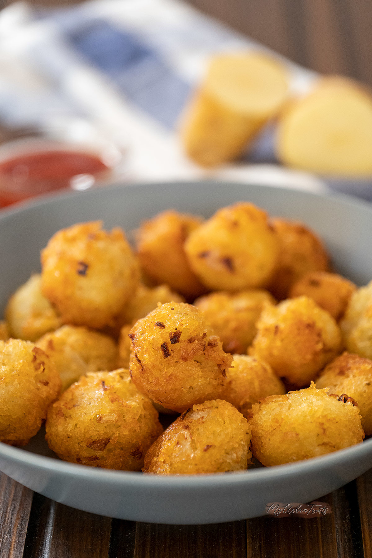 A plate of tater tots on a wooden surface