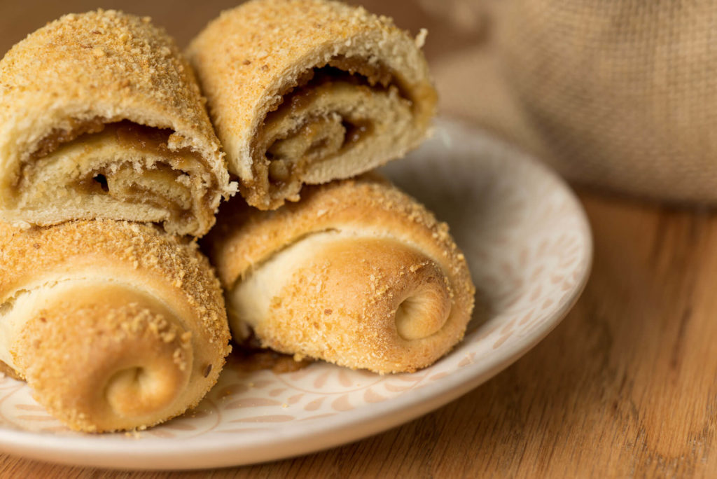A plate of Senorita rolls, one cut in half to reveal the delicious sugar paste filling inside.