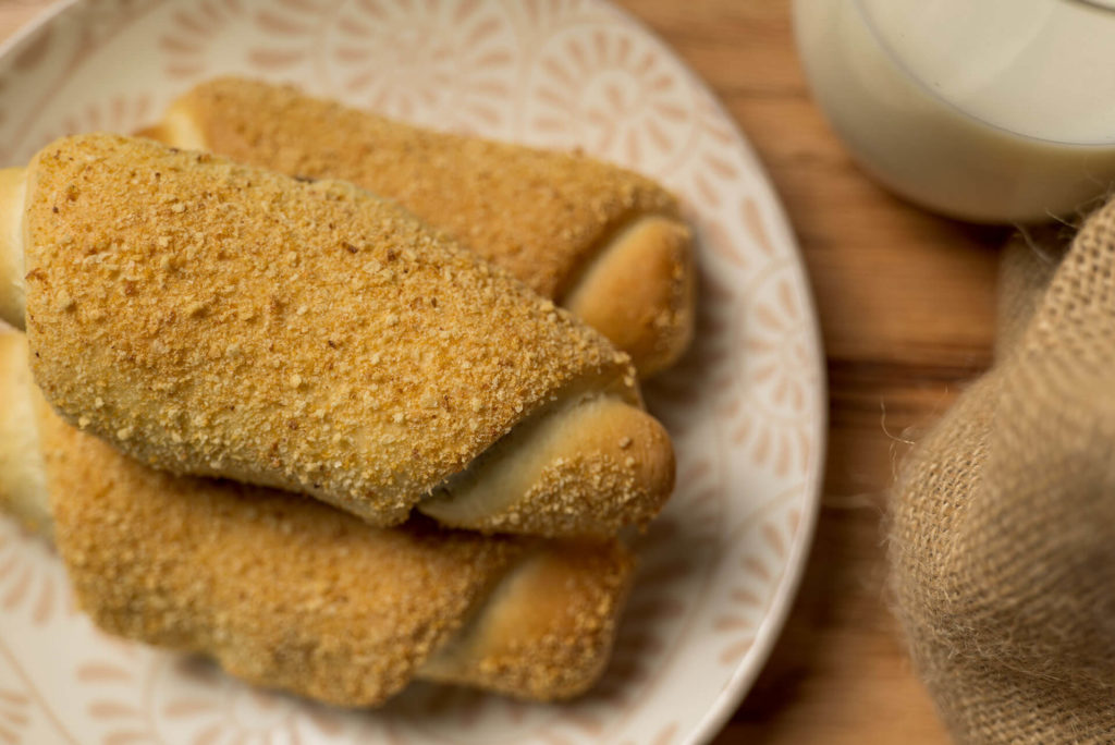 Three delicious Senorita bread rolls on a plate with crispy breadcrumbs, perfect for a sweet breakfast or snack.