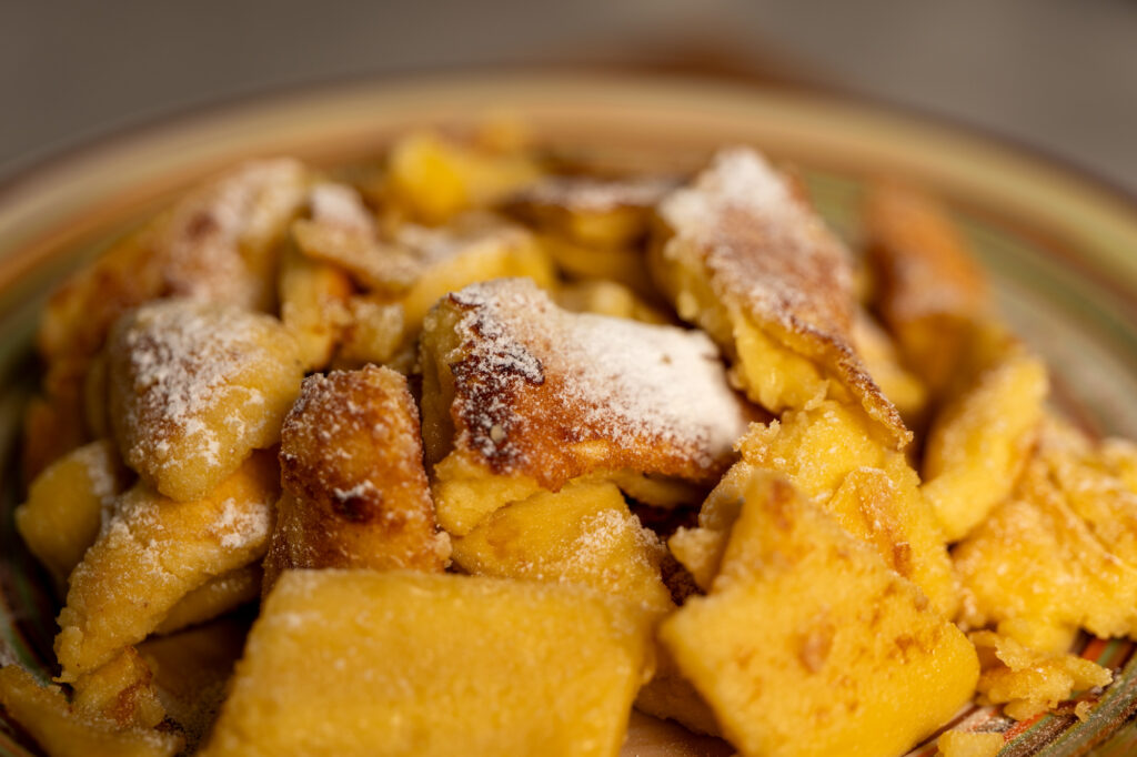 Close-up of caramelised Kaiserschmarrn pieces dusted with powdered sugar