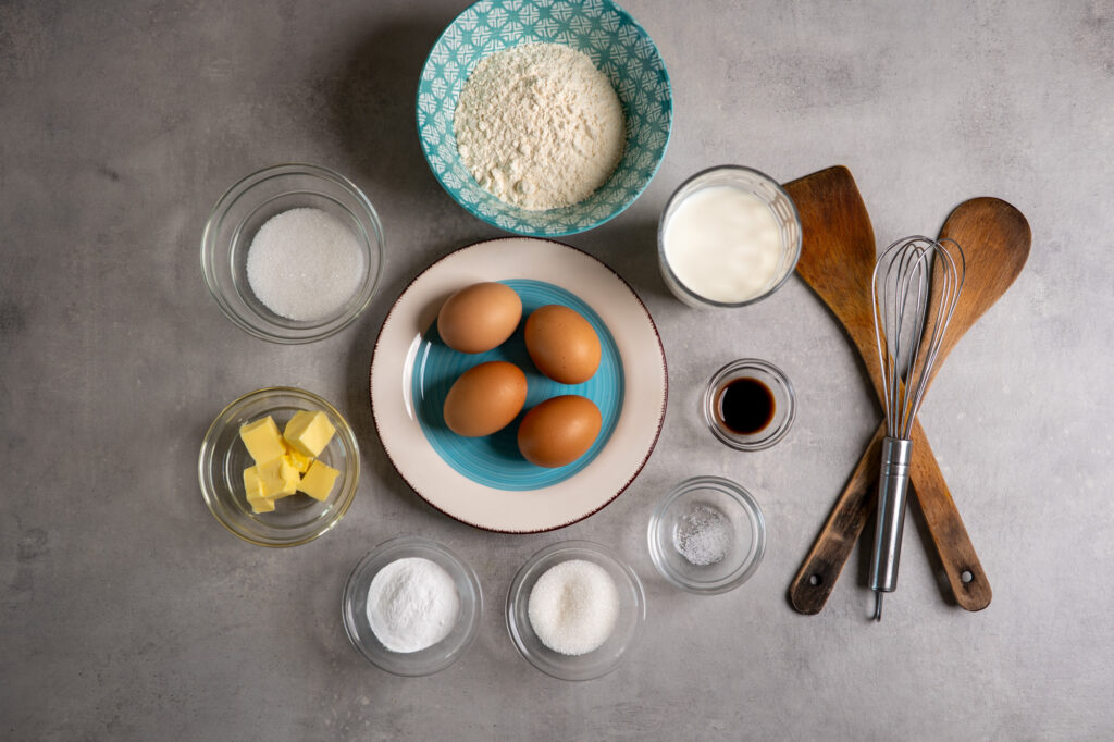 Kaiserschmarrn ingredients laid out: eggs, flour, milk, sugar, butter, vanilla and salt