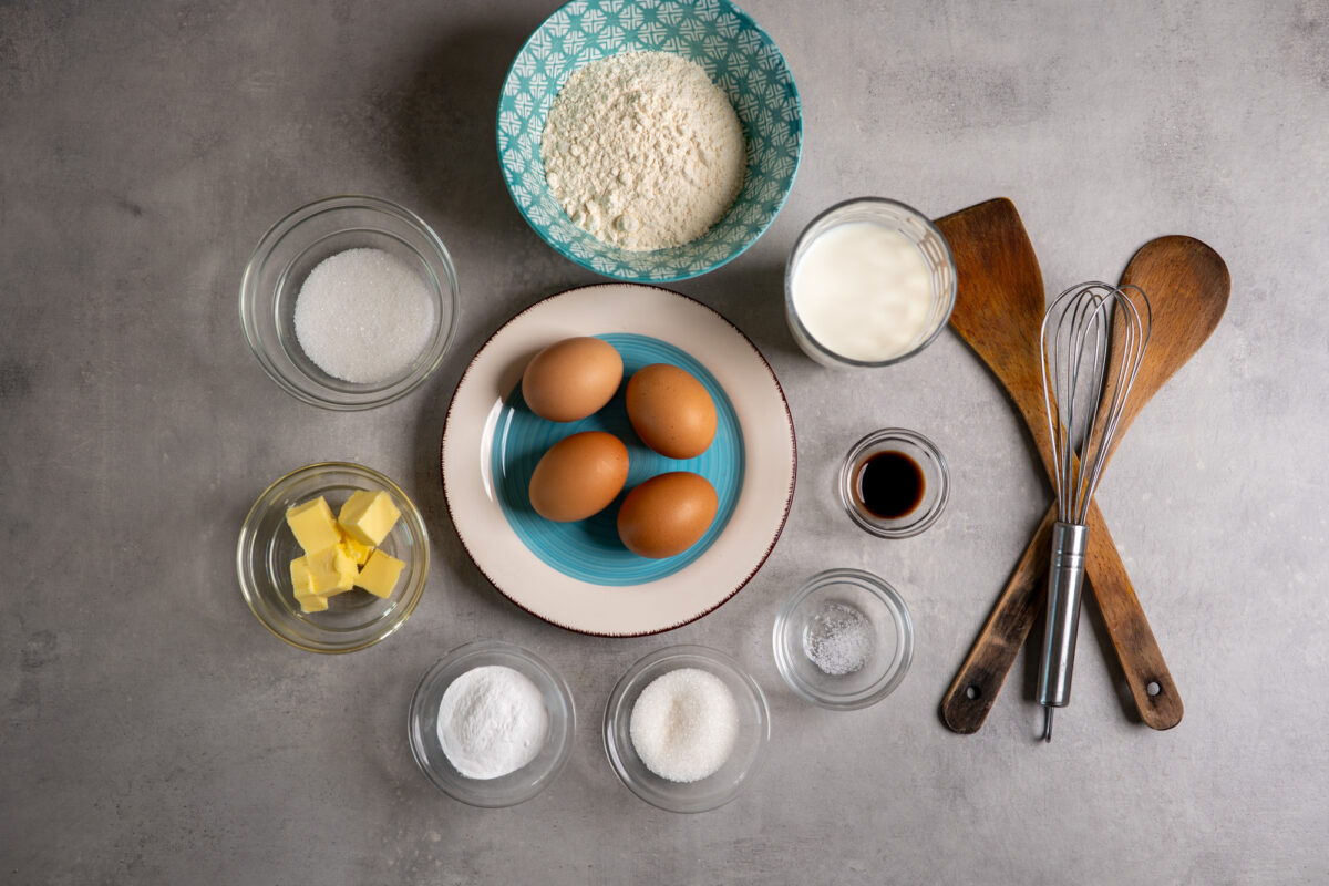 Kaiserschmarrn ingredients laid out: eggs, flour, milk, sugar, butter, vanilla and salt