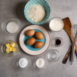 Kaiserschmarrn ingredients laid out: eggs, flour, milk, sugar, butter, vanilla and salt