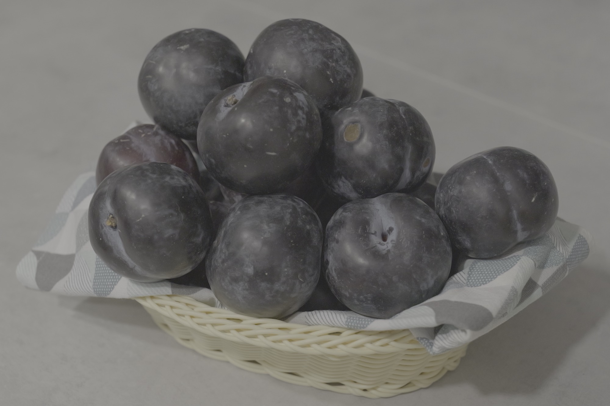 Dark round plums in a basket - the Cyprus market haul