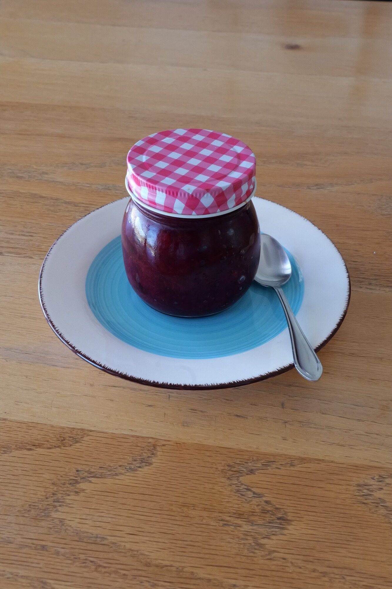 Sealed jar of homemade Austrian Powidl with a gingham lid