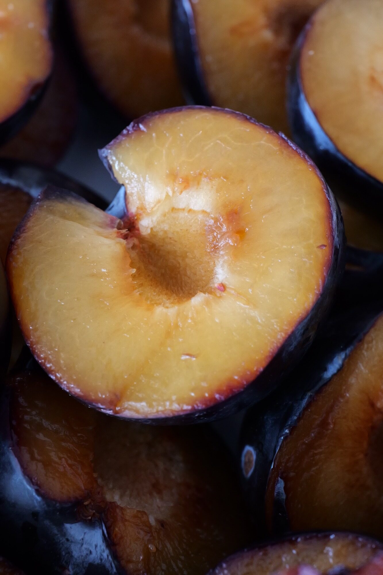 Halved dark plum with golden flesh in close-up